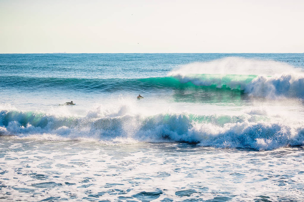 Perfecto rompiendo olas azules y surfistas
 - Foto, imagen