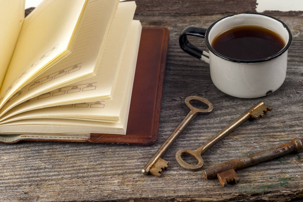παλιά κλειδιά, βιβλίο, κέικ με φλιτζάνι τσάι σε ρουστίκ ξύλινα φόντο. - Φωτογραφία, εικόνα
