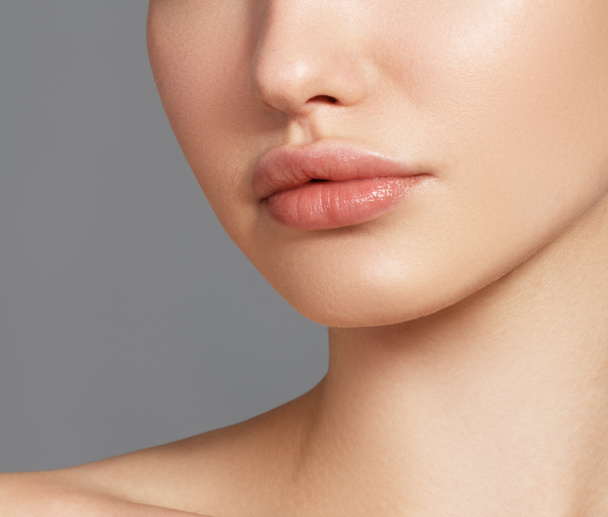 Sexy mollige volle lippen. Close-up oppervlakdetail. Perfecte natuurlijke lip make-up. Close-up foto met mooie vrouwelijke gezicht - Foto, afbeelding