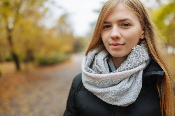Portrait of a beautiful, sweet, cheerful girl who walks in the Park in autumn season - Foto, Imagem