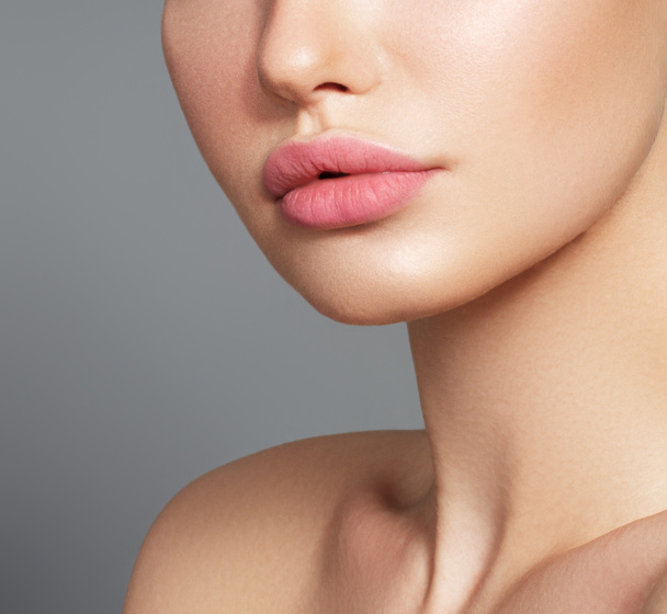 Sexy mollige volle lippen. Close-up oppervlakdetail. Perfecte natuurlijke lip make-up. Close-up foto met mooie vrouwelijke gezicht - Foto, afbeelding