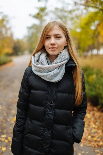 Portrait of a beautiful, sweet, cheerful girl who walks in the Park in autumn season - Foto, afbeelding