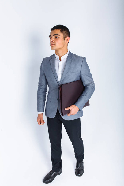 Handsome man with folder man reading a menu, a stylish business guy in suit in Studio on white background - Foto, afbeelding