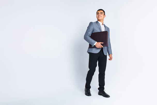 Handsome man with folder man reading a menu, a stylish business guy in suit in Studio on white background - Foto, imagen