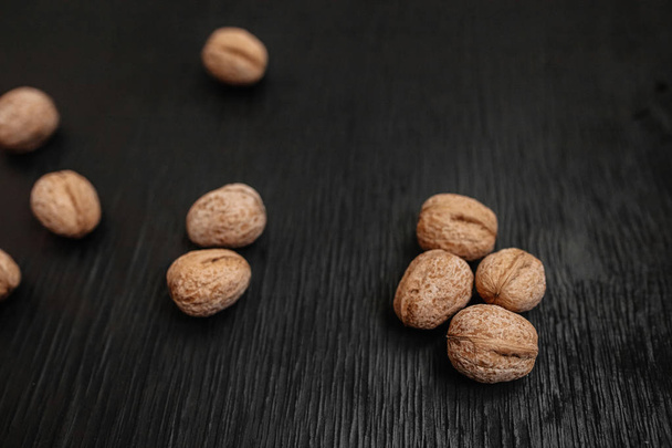 Lots of fresh nuts on a black wooden background. Best practices for designer - Valokuva, kuva