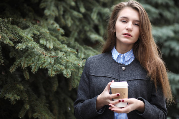 jovem com uma xícara de papel de café ao ar livre
 - Foto, Imagem