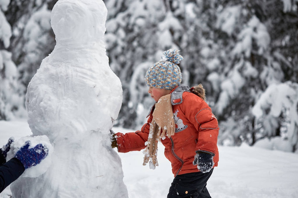 зимнее веселье. мальчик лепит снеговика
. - Фото, изображение