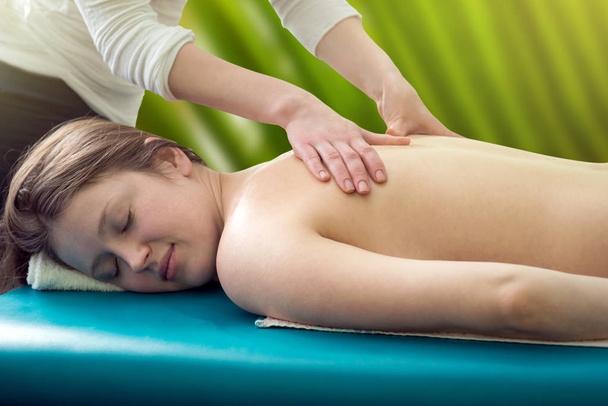 Massageie as costas de uma jovem
 - Foto, Imagem