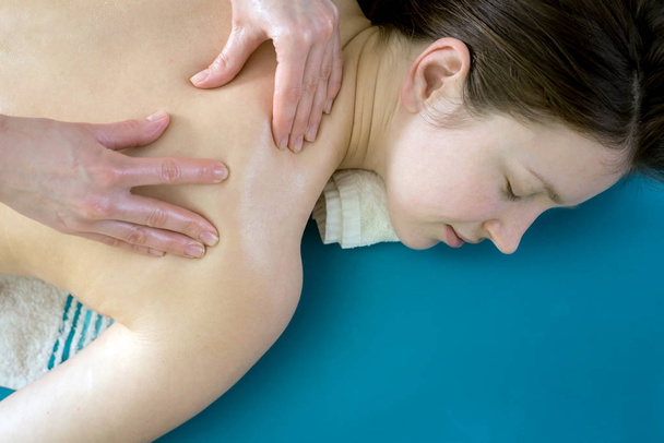 Masér dělá masáž na rameni dívky - Fotografie, Obrázek