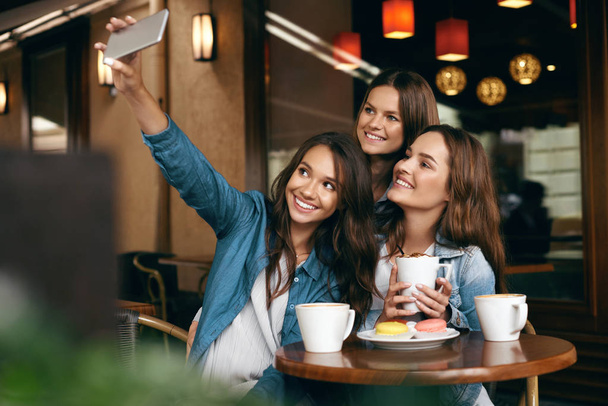 Women Meeting In Cafe. Friends Taking Photo On Phone. - Foto, Bild