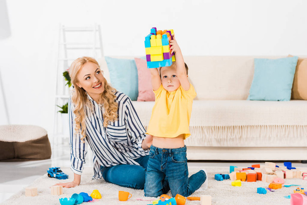madre e hijo pequeño jugando con juguetes juntos en el suelo en casa
 - Foto, Imagen