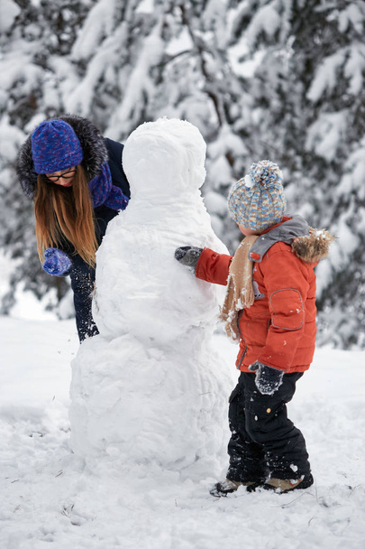 Zimowe zabawy. dziewczyna i chłopak, Dokonywanie śnieżkami. - Zdjęcie, obraz