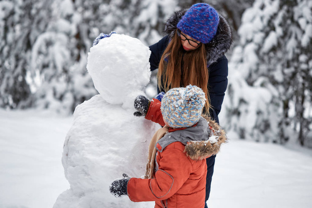 Diversão de inverno. uma menina e um menino fazendo bolas de neve
. - Foto, Imagem