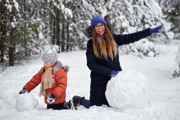 Diversión invernal. una chica y un chico haciendo bolas de nieve
. - Foto, imagen