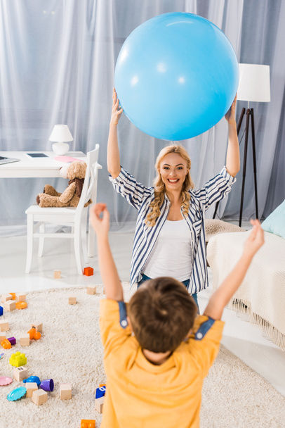 mãe feliz e filho brincando com bola de fitness juntos em casa
 - Foto, Imagem