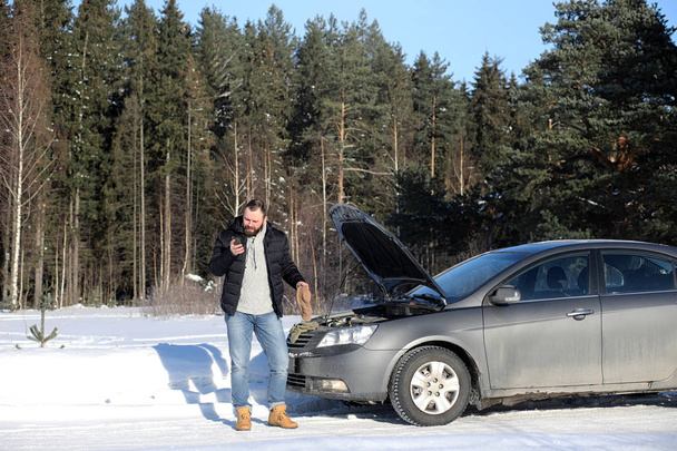 Man stands outdoor near broken car - Valokuva, kuva