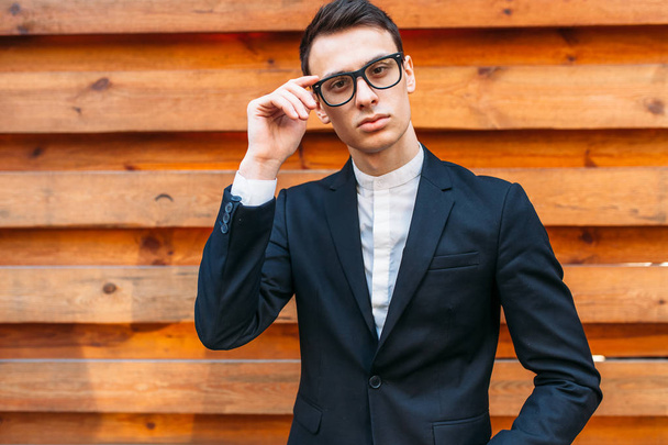 Stylish, man in classic costume, posing near wooden wall. Business style, life, work. - Foto, Imagem