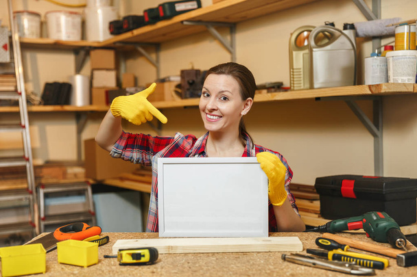 Young woman in plaid shirt, gray T-shirt, yellow gloves working  - Photo, Image