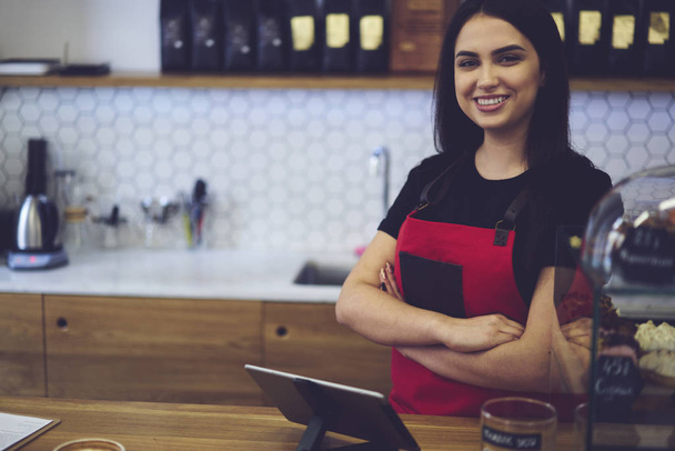 Waitress in good mood greeting clients with nice smile offering coffee drinks - Photo, Image