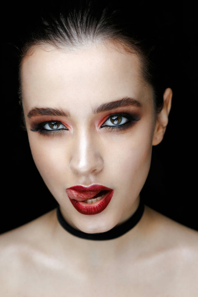 Close-up portrait of gorgeous young woman with fashion make-up against black background  - Zdjęcie, obraz