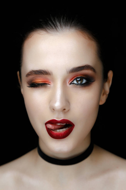 Close-up portrait of gorgeous young woman with fashion make-up against black background  - 写真・画像