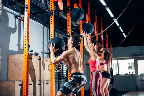 fit, sport and exercising concept - people with medicine balls training in gym - 写真・画像