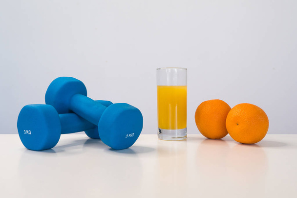The concept of a healthy diet. Small dumbbells. Orange juice. Measuring tape waist. Oranges. on a white background. healthy lifestyle. sport. Fitness food. - Valokuva, kuva