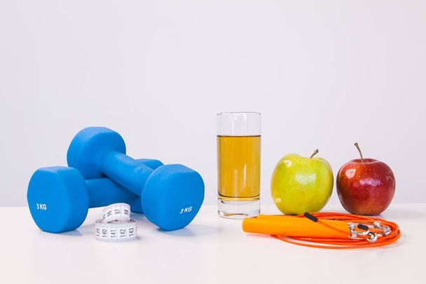 The concept of a healthy diet. Small dumbbells. Apple juice. The skipping rope. Green apple. Red Apple. on a white background. healthy lifestyle. sport. Fitness food. - Valokuva, kuva