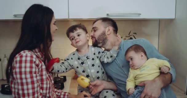 Primer plano familia joven sonriendo pasar tiempo juntos en la cocina con sus hijos. 4k. épica roja
 - Metraje, vídeo