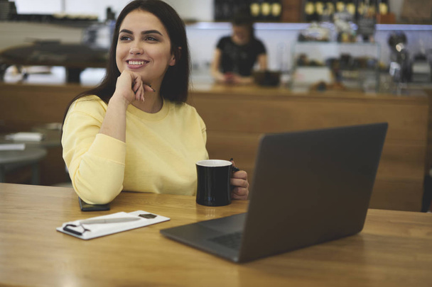 Female freelancer enjoying working time in coffee shop - Photo, image