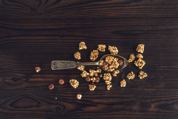 vista superior de granola crocante e avelãs na colher na mesa de madeira
 - Foto, Imagem