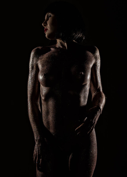 zdobení těla s fialové flitry na kůži krásné nahé dívky na tmavém pozadí - Fotografie, Obrázek