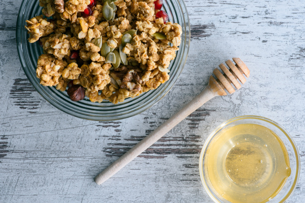 top view of granola and glass bowl with honey on table - Photo, Image