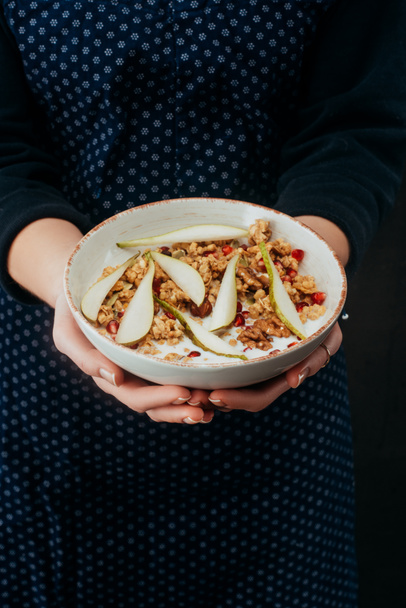 cropped image of woman holding bowl with homemade granola - Photo, Image