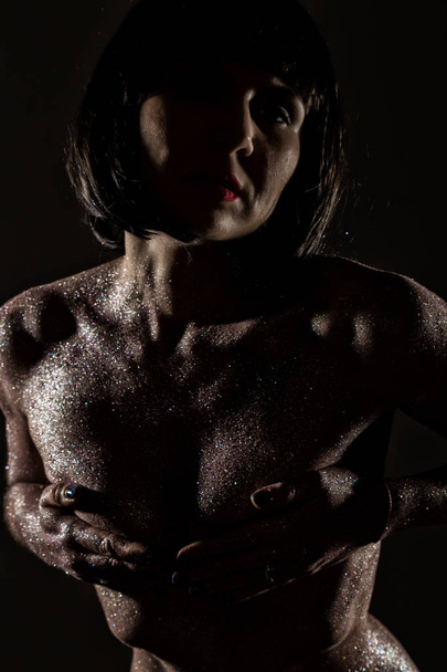 body art with purple sequins on a skin of beautiful nude girl on dark background - Photo, image