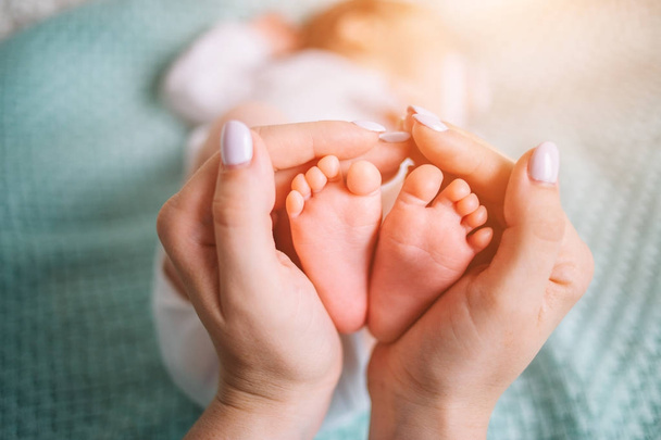 Parent holding in the hands feet of newborn baby. - Zdjęcie, obraz