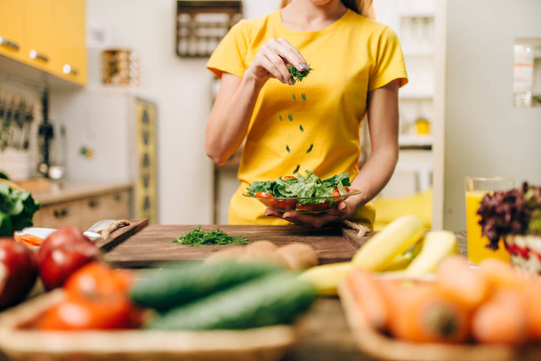 Žena, vaření salát v kuchyni, zdravé jídlo. Vegetariánská strava, čerstvá zelenina a ovoce na dřevěný stůl - Fotografie, Obrázek