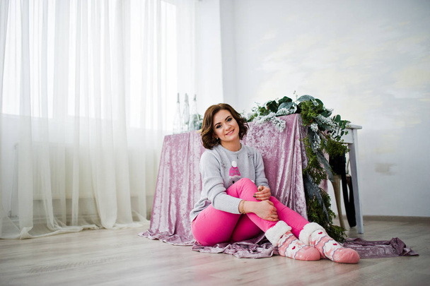Girl wear on winter sweater sitting against table at room with c - Фото, зображення