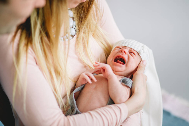 newborn cries in arms of his mother - 写真・画像