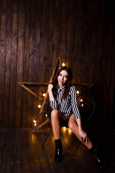 Girl posed against light star at studio with wooden background. - 写真・画像