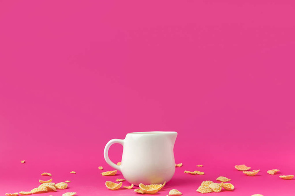 vista ravvicinata di brocca con latte e fiocchi di mais croccanti su rosa
 - Foto, immagini
