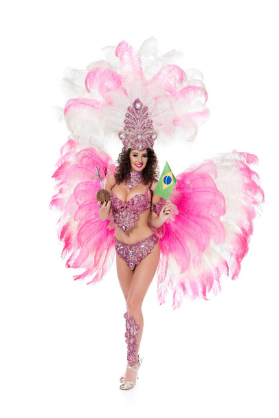 vrouw in Carnaval kostuum houden van kokosnoot met rietjes en Braziliaanse vlag, geïsoleerd op wit  - Foto, afbeelding