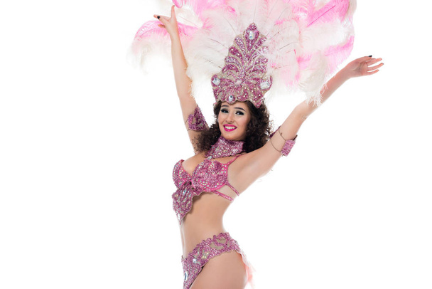 Cheerful woman in carnival costume with pink feathers with hands raised elated isolated on white - Zdjęcie, obraz