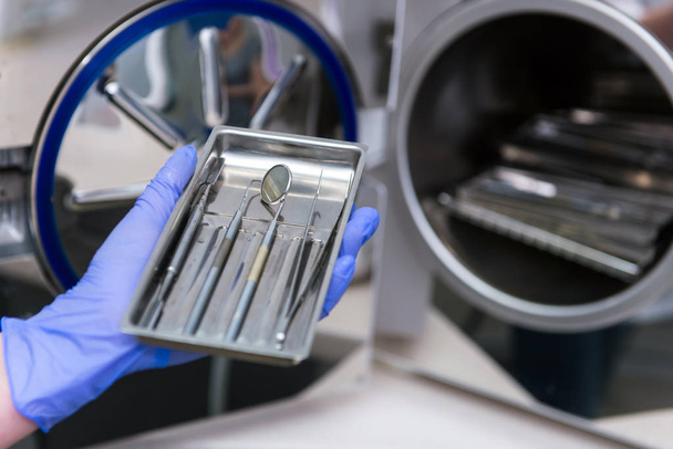 The doctor sterilizes instruments in special equipment in the clinic - Foto, Bild