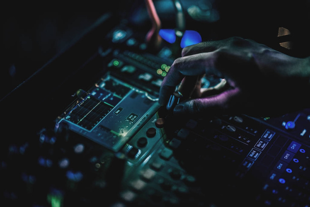 DJ equipment professional gear concept. Close up of DJ mixing equipment and gears real female DJ's hand in real night club, selective focus and low light environment. - Fotó, kép