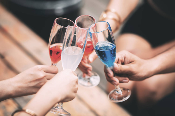 Vrienden hand met champagneglazen een toast te maken. Genomen in echte pub-instellingen. - Foto, afbeelding