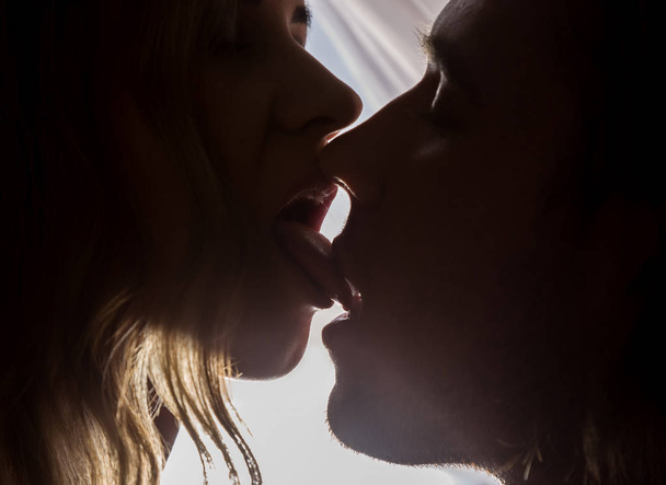 Close-up of young couple in passionately kissing on bright background - Foto, Imagen