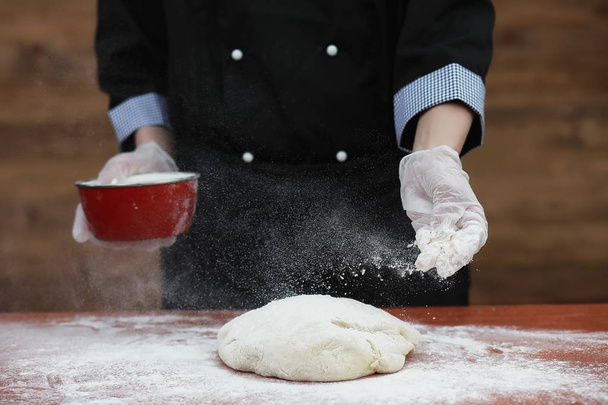 the cook makes flour for baking on the table - Photo, Image