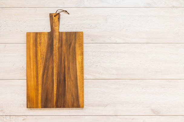 Tabla de cortar madera sobre fondo de madera con espacio de copia
 - Foto, Imagen