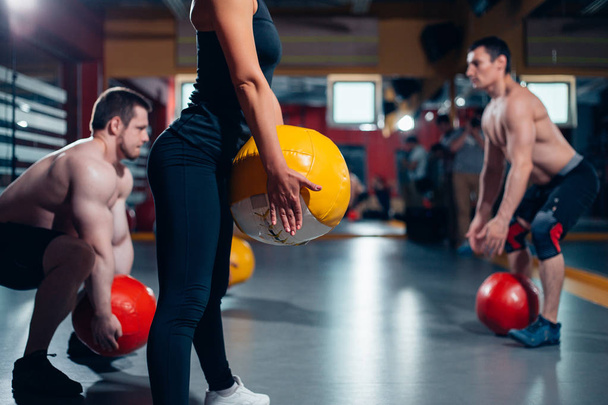 сильные мужчины и женщины тренируются с мячом
 - Фото, изображение